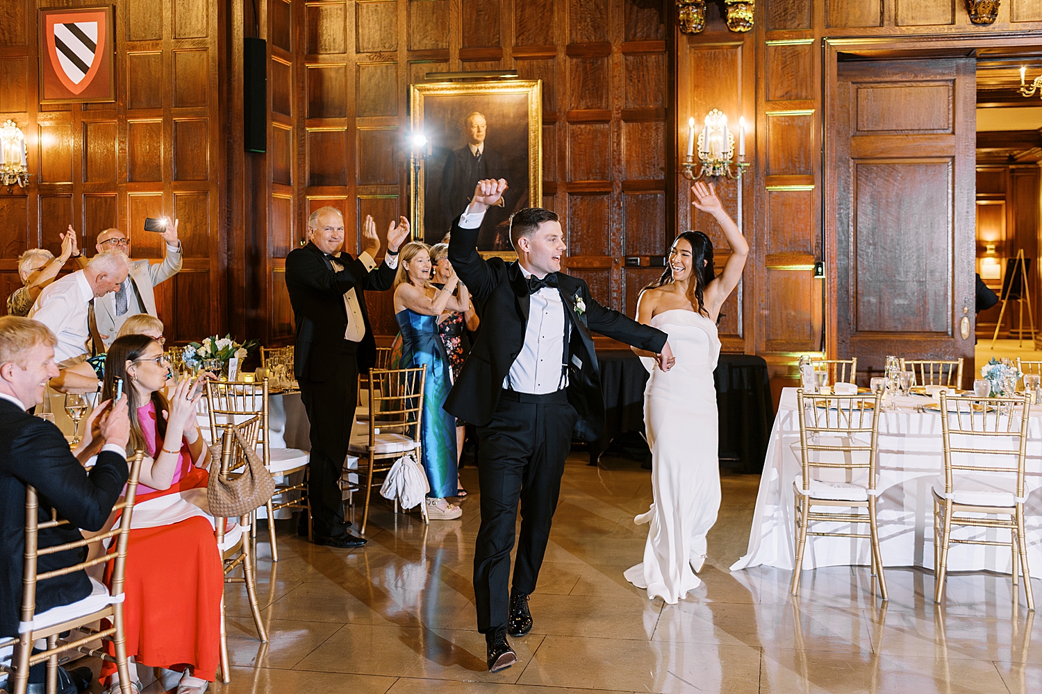 newlyweds enter reception with hands up in celebration by Lynne Reznick Photography
