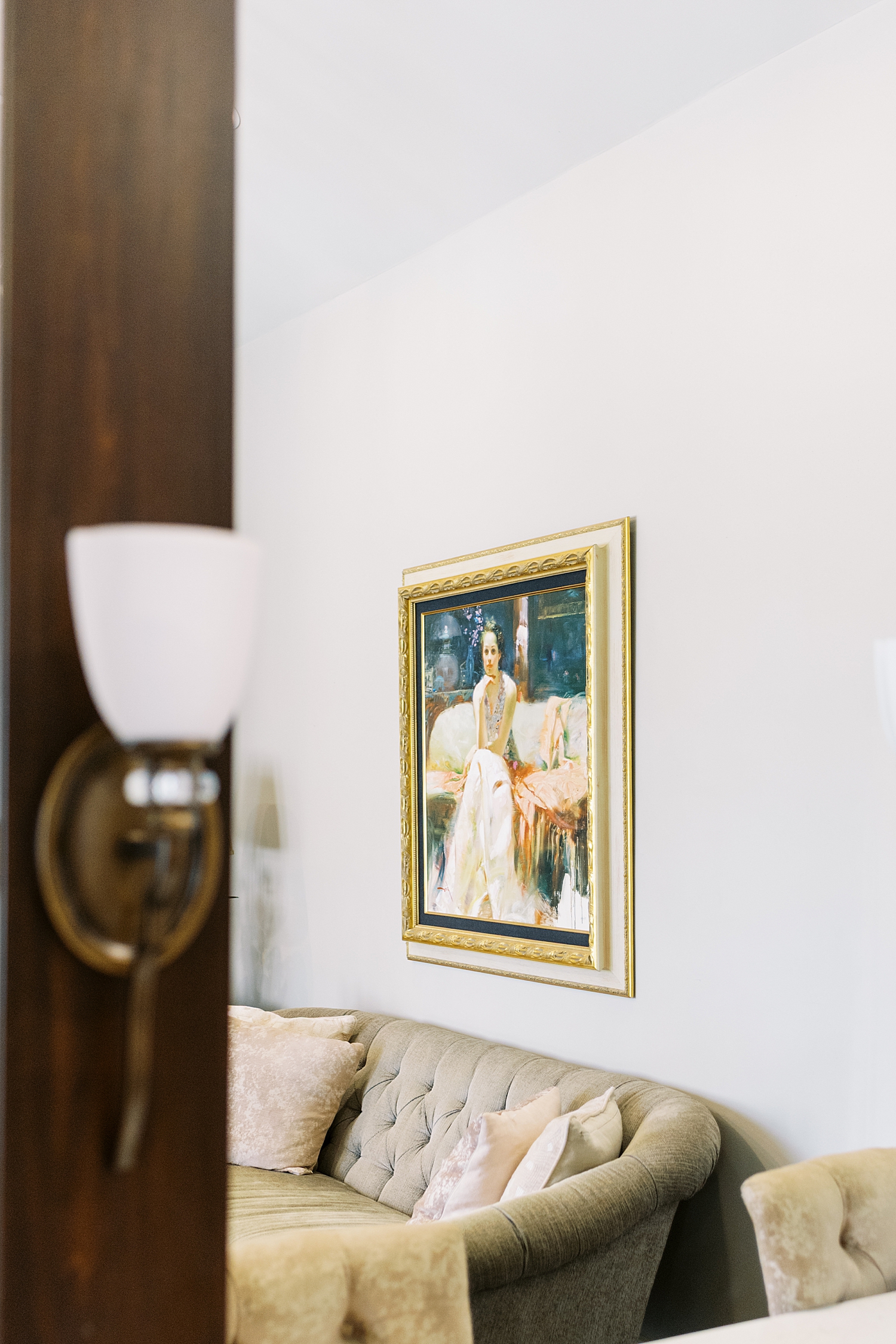 painting in gold frame over tufted couch by Austin wedding photographer