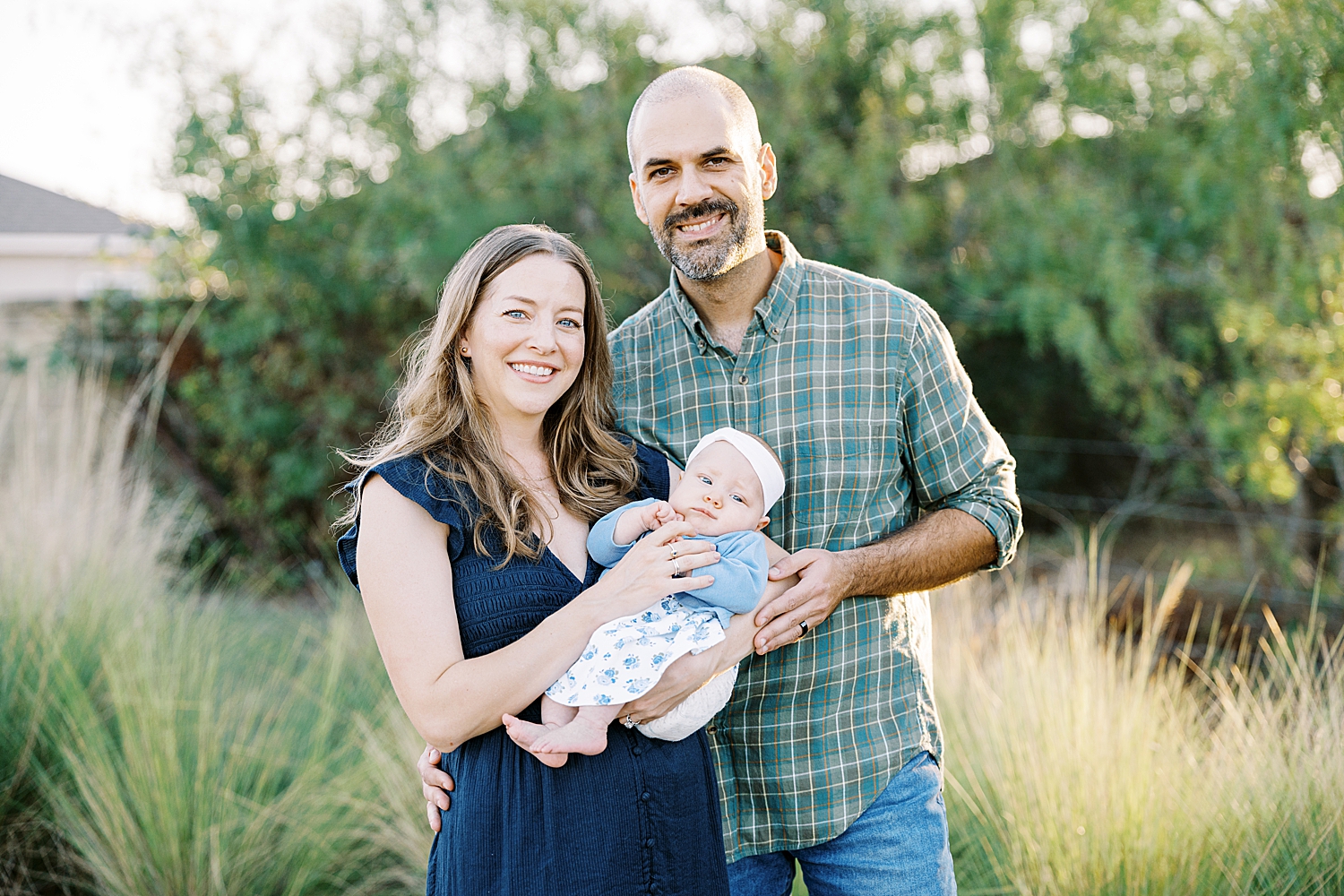 man and woman stand outside with new daughter by Austin photographer