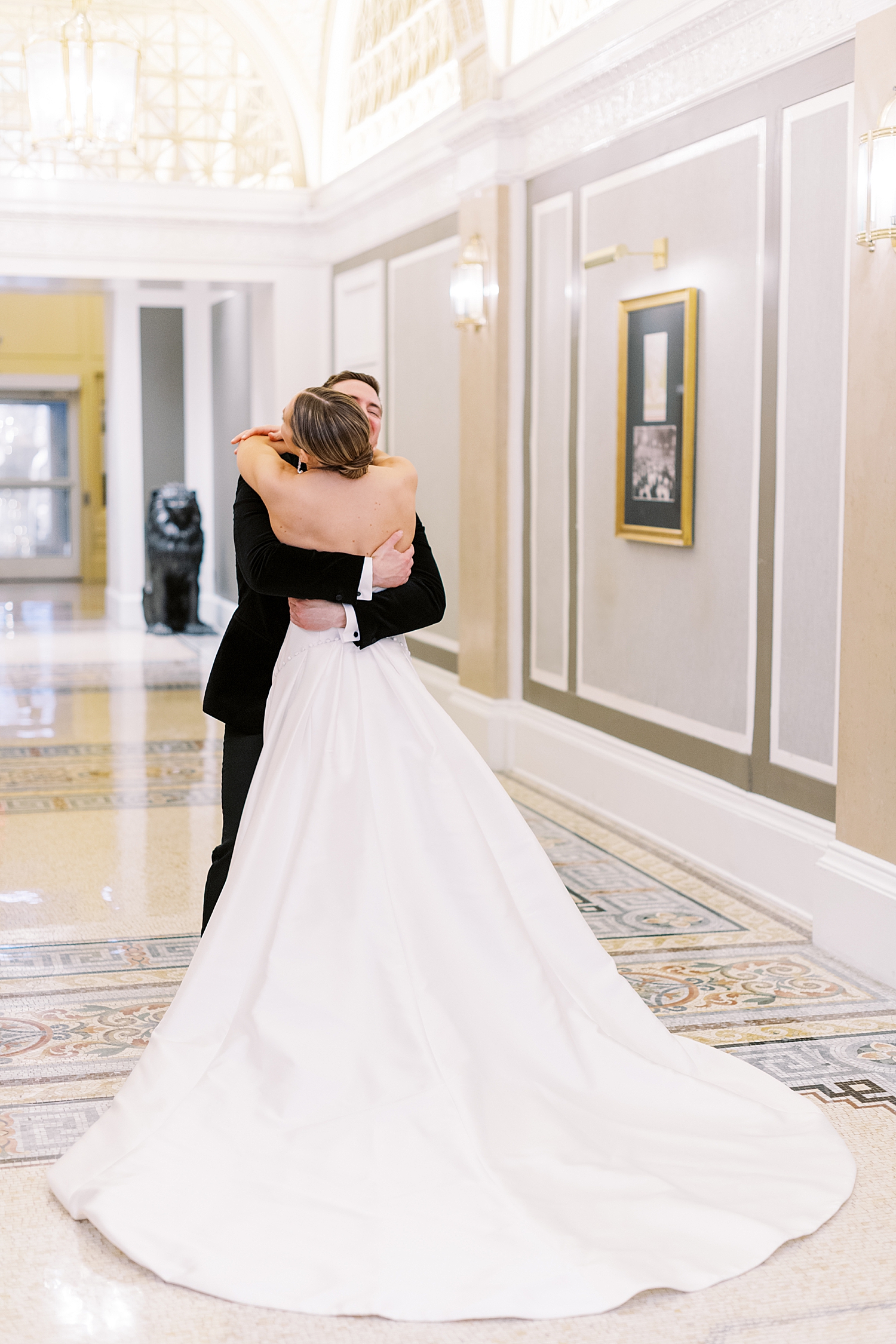 groom reaches around bride for giant hug during first look by Boston photographer