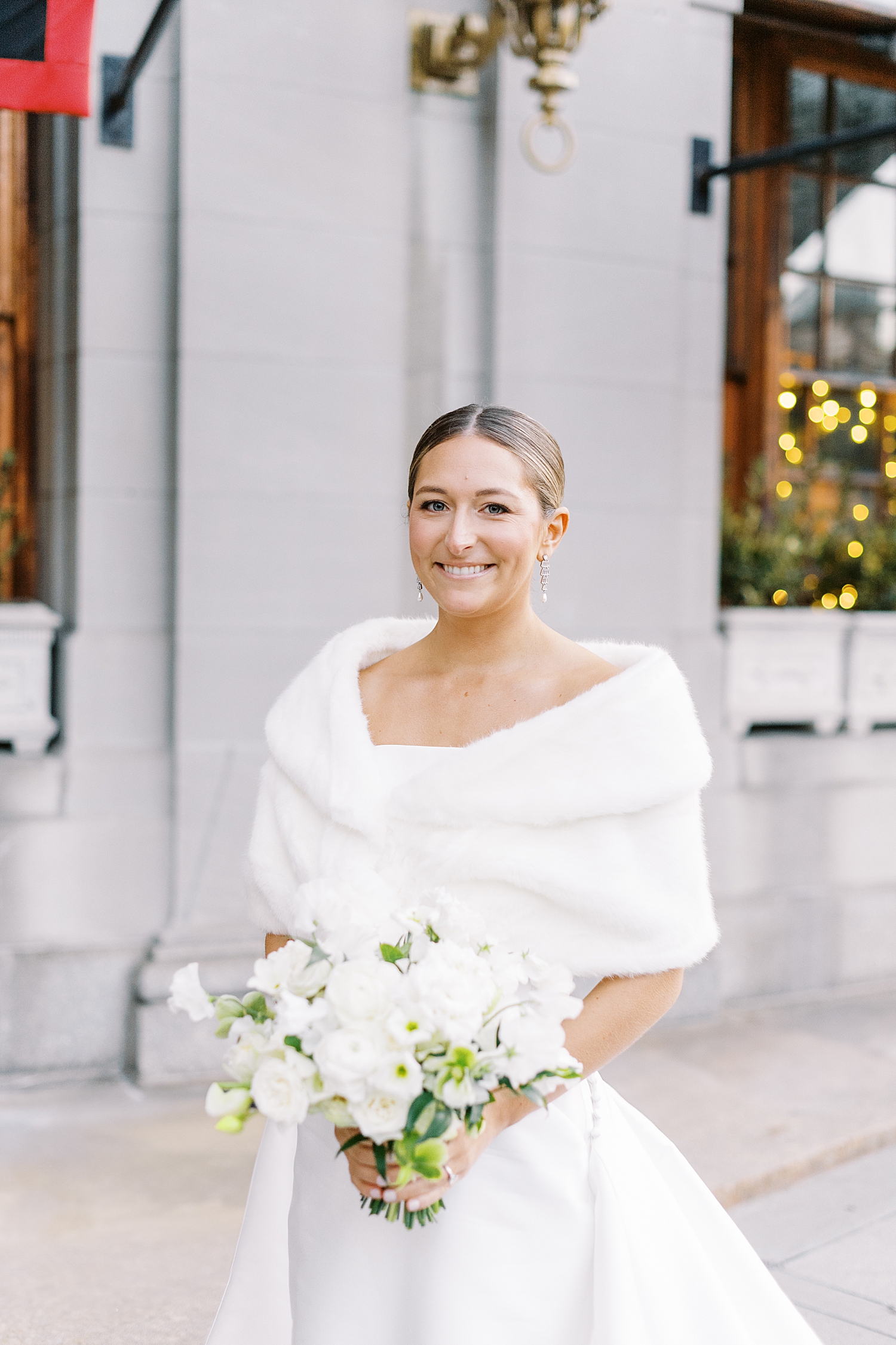 woman in white gown and fur stand on sidewalk in cold by Boston photographer