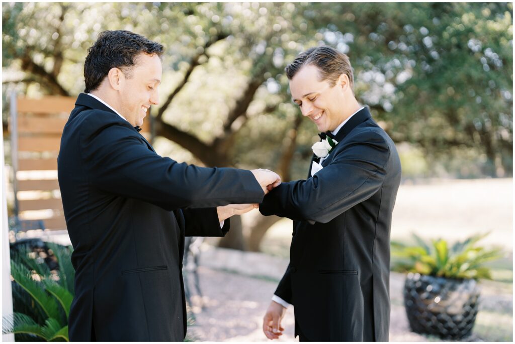 Groom and best man adjusting cufflinks in at Addison Grove