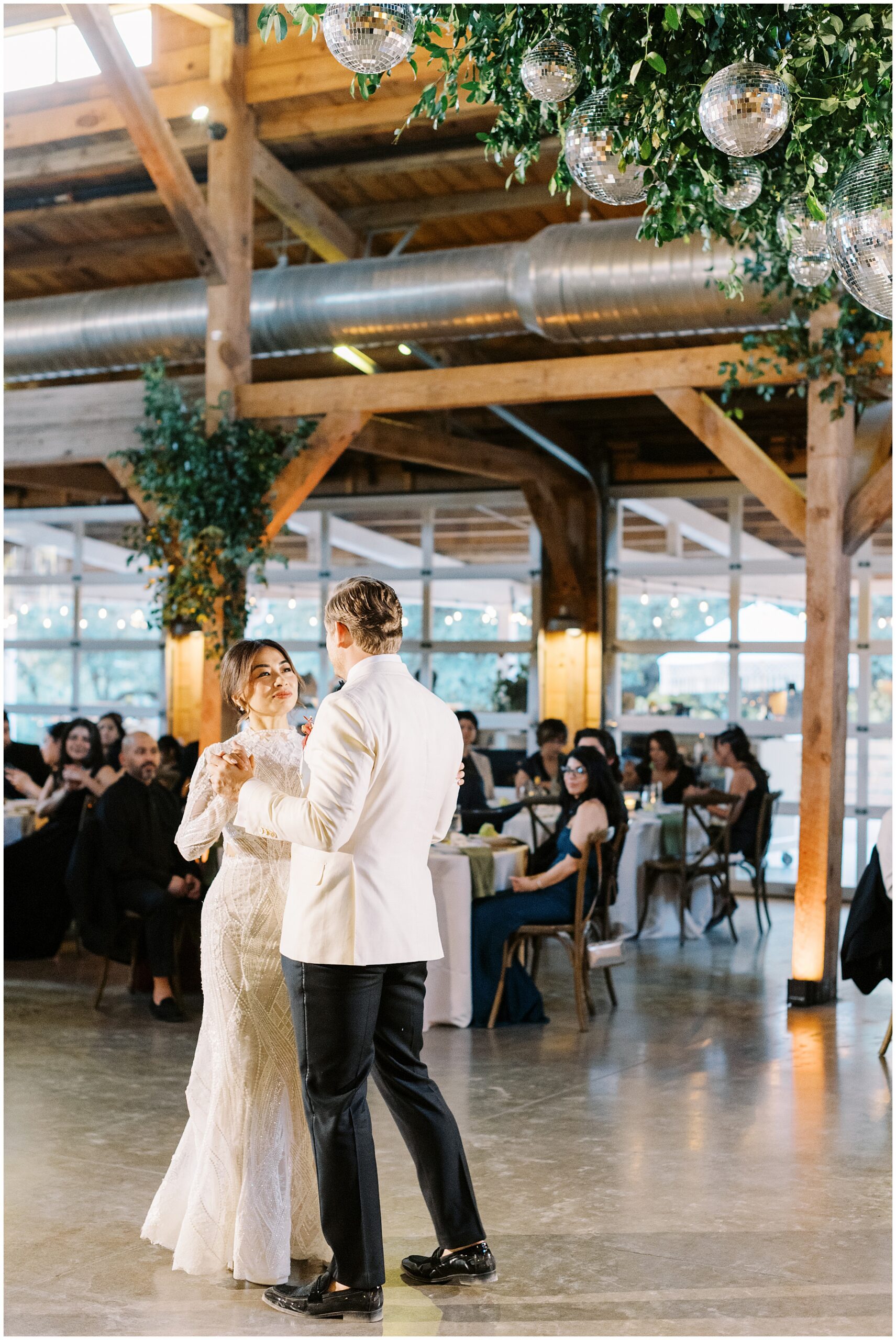 First dance under warm lighting in Addison Grove barn reception space