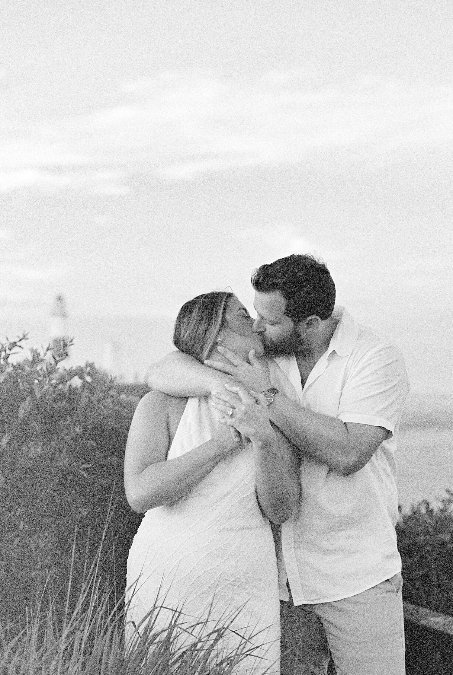 husband-to-be hugs wife and brings her in for a kiss for Montauk engagement session