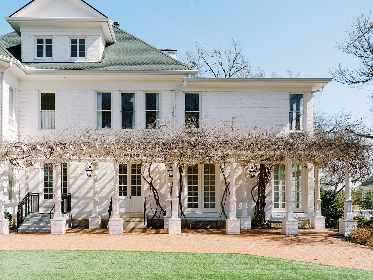 large manor with trellis outside by Lynne Reznick Photography 