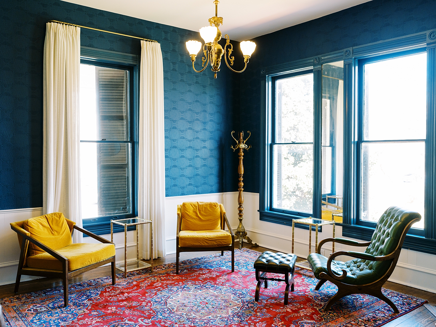 deep blue room with vintage rug on floor at Woodbine Mansion